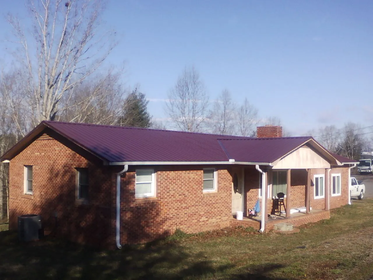 Burgundy metal roof on a brick ranch home with a new addition in Goodlettsville