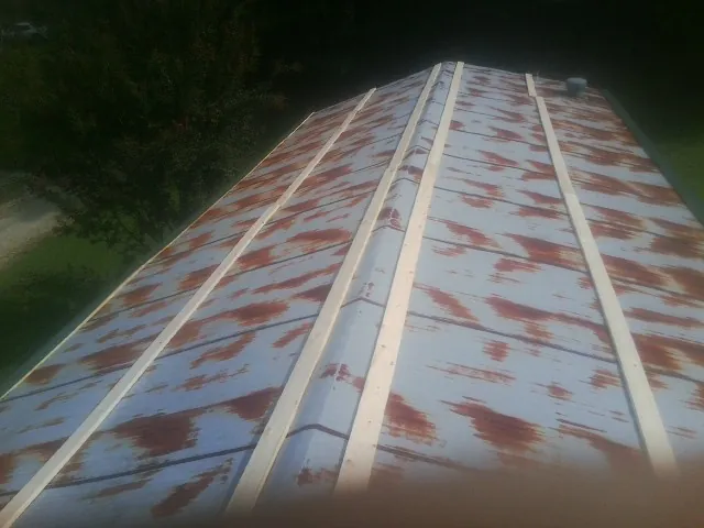 Rusted metal roof panels with new wood purlins before replacement — Storm Damage Roof Repair in Goodlettsville by Roofing Brothers