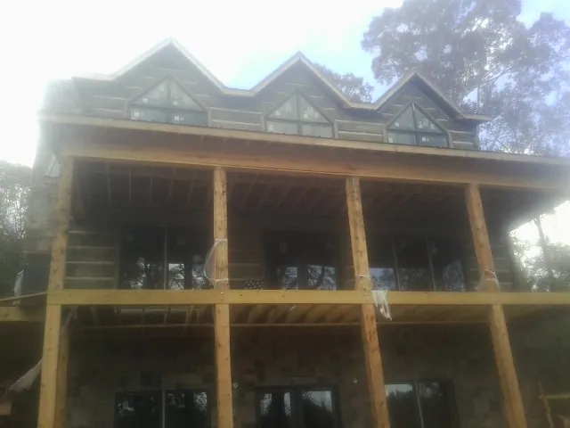 Dormers and porch framing on a large log home under construction — Roof Coating work by our crew in Goodlettsville