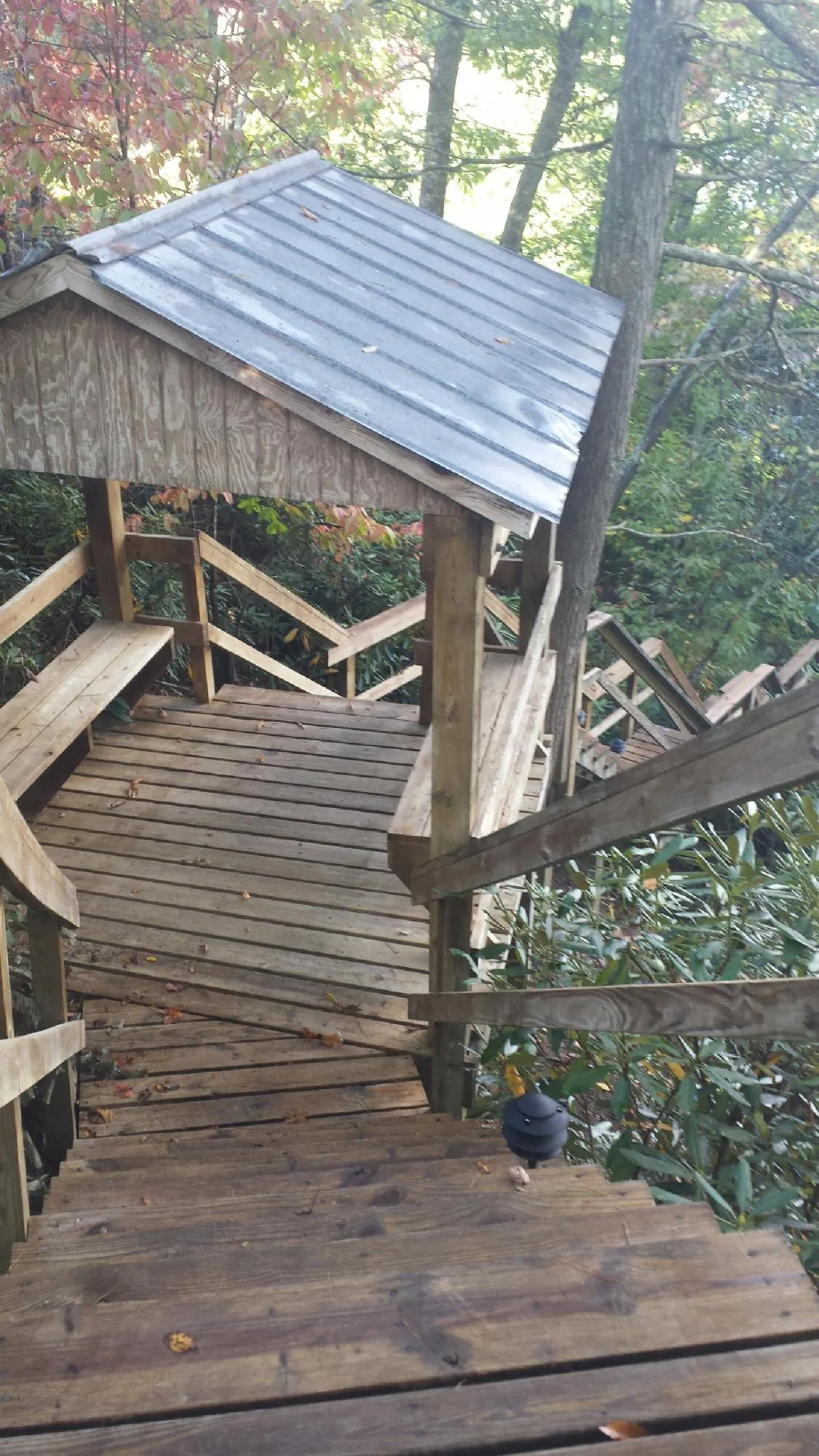Metal roofed shelter over wooden steps on a wooded walkway — Skylight Repair & Installation work by our crew in Goodlettsville