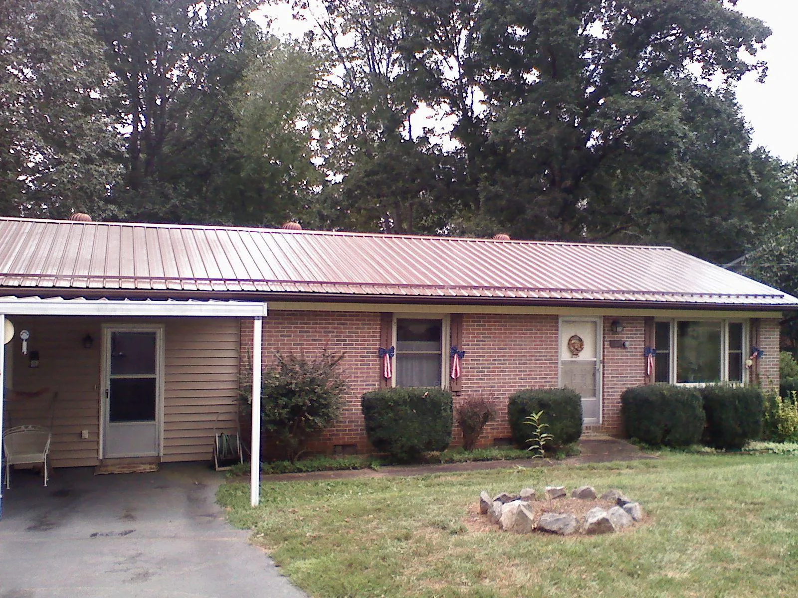 Bronze metal roof and carport on a brick ranch home — Roof Repair work by our crew in Goodlettsville